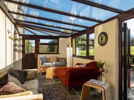 A conservatory with seating and a glass ceiling at Trehaverock Cottage St. Endellion near Port Isaac
