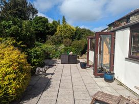 A garden with a patio and a dog at Trehaverock Cottage St. Endellion near Port Isaac