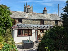 A conservatory with a table and chairs at Trehaverock Cottage in St. Endellion near Port Isaac