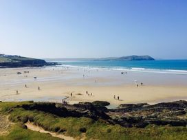 A beach view with people and ocean at Trehaverock Cottage in St. Endellion near Port Isaac