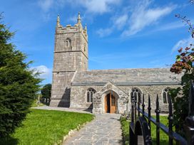 A church with a tower and pathway at Trehaverock Cottage in St. Endellion near Port Isaac
