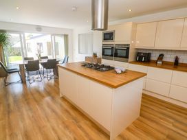 A kitchen with a dining table and gas stove at Agan Paradhis in Quintrell Downs