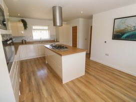 A kitchen with an island and gas stove at Agan Paradhis in Quintrell Downs