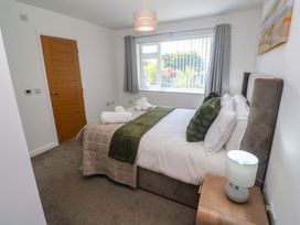 A bedroom with a bed and a lamp at Agan Paradhis in Quintrell Downs