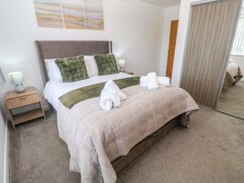 A bedroom with a bed and bedside table at Agan Paradhis in Quintrell Downs