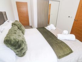A bedroom with a bed and towels at Agan Paradhis in Quintrell Downs