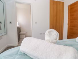A bathroom with a toilet and vanity visible from a bedroom at Agan Paradhis in Quintrell Downs