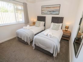 A bedroom with twin beds and a bedside table at Agan Paradhis in Quintrell Downs