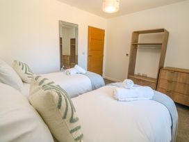 A bedroom with two beds and a wardrobe at Agan Paradhis in Quintrell Downs