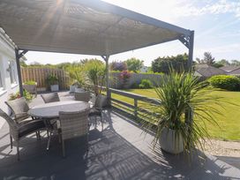 An outdoor seating area with a table and chairs under an umbrella at Agan Paradhis Quintrell Downs