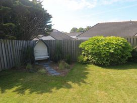 A garden with a bench and bush at Agan Paradhis in Quintrell Downs