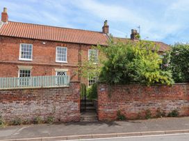 A brick house with windows and a gate at Reighton House in Filey