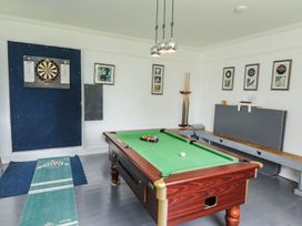 A game room with a pool table and dartboard at Reighton House in Filey