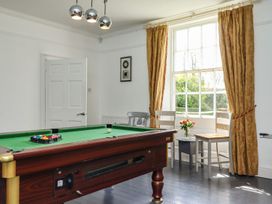 A game room with a pool table and chairs at Reighton House in Filey