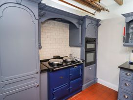 A kitchen with cabinetry and stove at Reighton House in Filey
