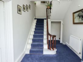 A hallway with stairs and a mirror at Reighton House in Filey