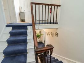 A stairwell with a handrail and carpet at Reighton House in Filey