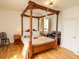 A bedroom with a four-poster bed and a sofa at Reighton House in Filey