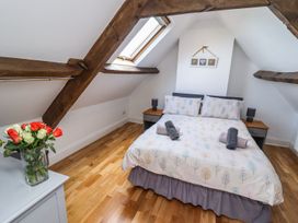 A bedroom with a bed and floral arrangement at Reighton House in Filey
