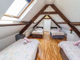 A bedroom with four beds and a door at Reighton House in Filey