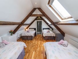 A bedroom with multiple beds and a shower at Reighton House in Filey