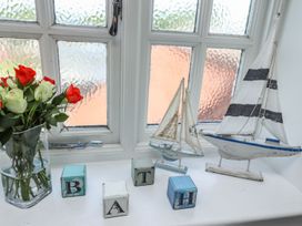 A vase with flowers and model ships on a window sill at Reighton House in Filey