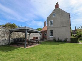 A garden with a gazebo and outdoor seating at Reighton House in Filey