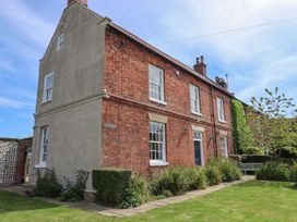 A house with brick exterior and garden at Reighton House in Filey