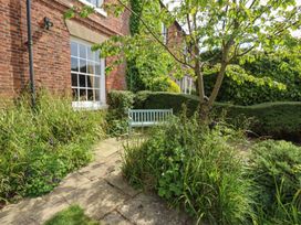 A garden with a bench and plants at Reighton House in Filey