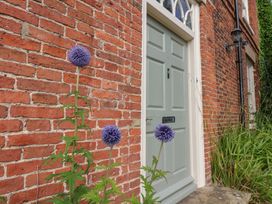 An entrance door with flowers in front of a brick wall at Reighton House Reighton near Filey