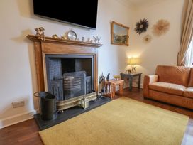 A living room with a fireplace and sofa at Reighton House in Reighton near Filey