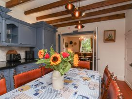 A kitchen with a dining table and flower vase at Reighton House in Reighton near Filey