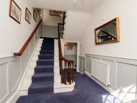 A staircase with framed pictures and a mirror in Reighton House Reighton near Filey