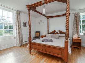 A bedroom with a four-poster bed and bedside tables at Reighton House in Reighton near Filey