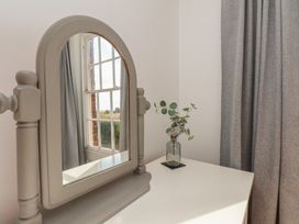 A mirror and plant on a table in a bedroom at Reighton House Reighton near Filey