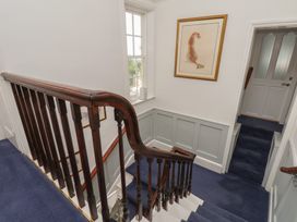 A staircase with a handrail and wall art at Reighton House in Reighton near Filey