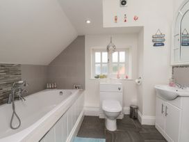A bathroom with a bathtub and sink at Reighton House in Reighton near Filey