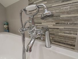 A bathtub with a chrome faucet and showerhead at Reighton House, Reighton near Filey