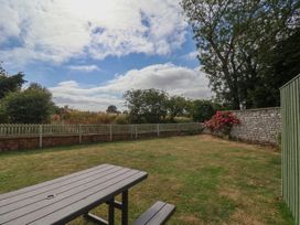 A garden with a table and flowers at Reighton House in Reighton near Filey