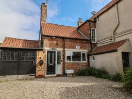 A house with a garage and gravel driveway at Reighton House in Reighton near Filey