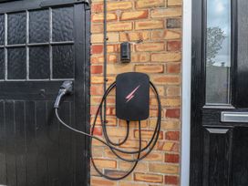 An electric vehicle charger on a brick wall at Reighton House near Filey