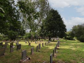 A cemetery with graves and trees at Reighton House in Reighton near Filey