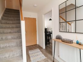 A hallway with stairs and a console table at 24 Higher Gorse Road Roughton