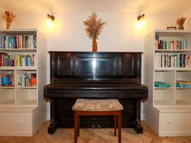 A living room with a piano and bookshelves at Seveock in Threemilestone