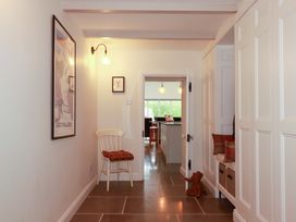 A hallway with a chair and storage unit at Seveock in Threemilestone