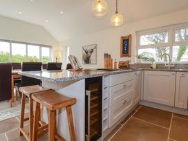 A kitchen with granite countertop and bar stools at Seveock in Threemilestone