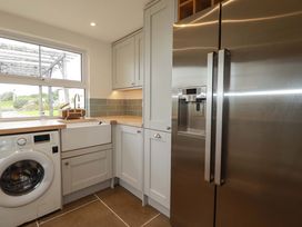 A utility room with a washing machine and sink at Seveock in Threemilestone