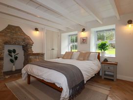 A bedroom with a bed and stone fireplace at Seveock in Threemilestone