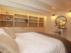A bedroom with a bed and a desk with a mirror at Seveock in Threemilestone