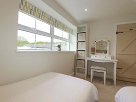 A bedroom with a bed, dresser and window at Seveock in Threemilestone